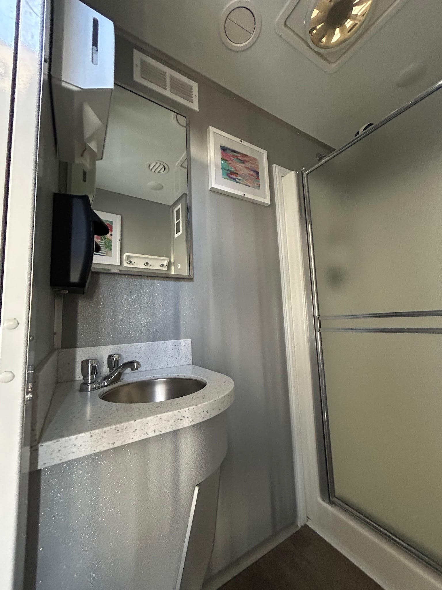 3-stall shower trailer interior — sink and mirror