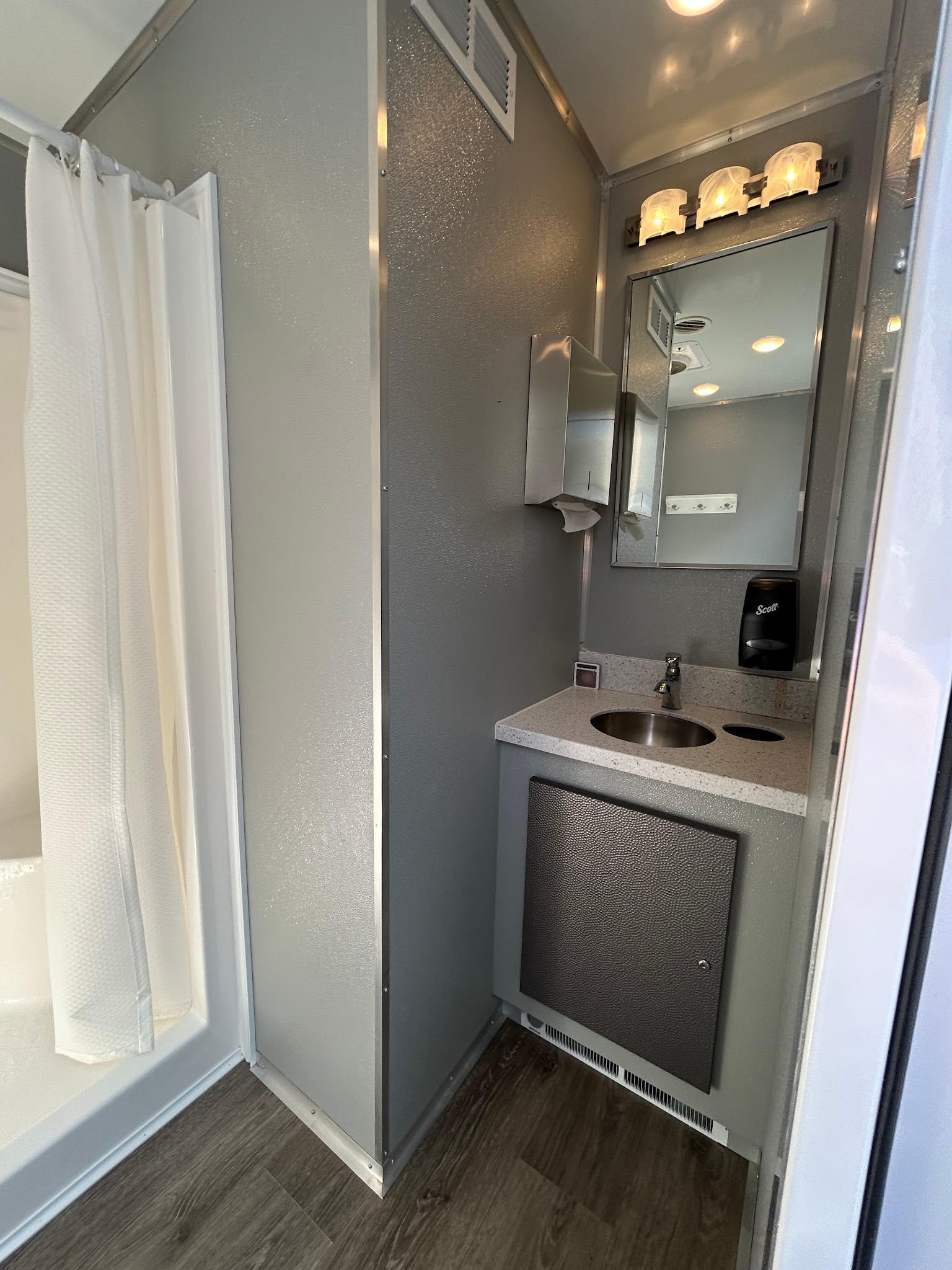 2-stall shower trailer interior — sink and mirror